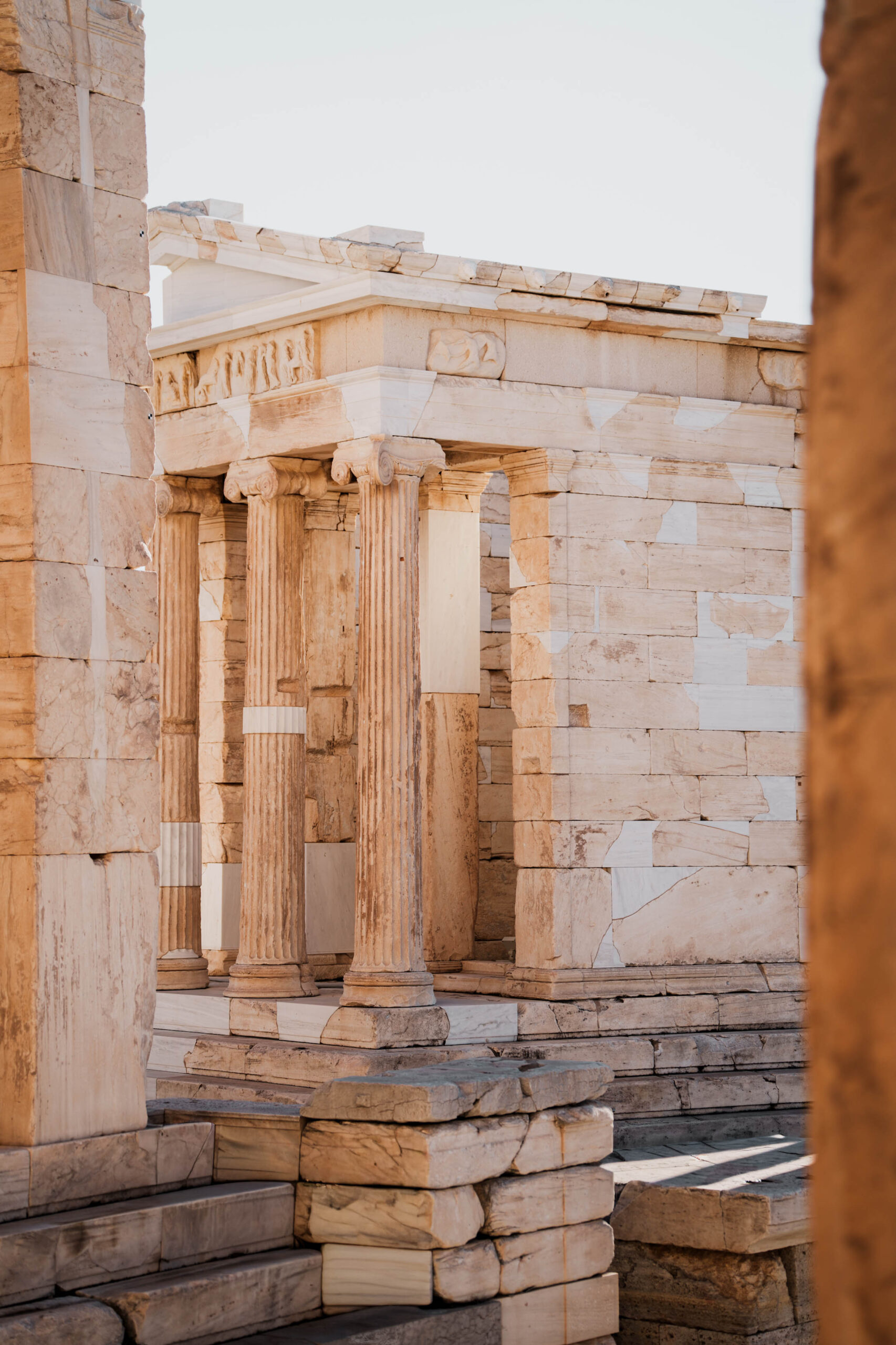 Ancient Greek columns at the Acropolis, bathed in soft golden light